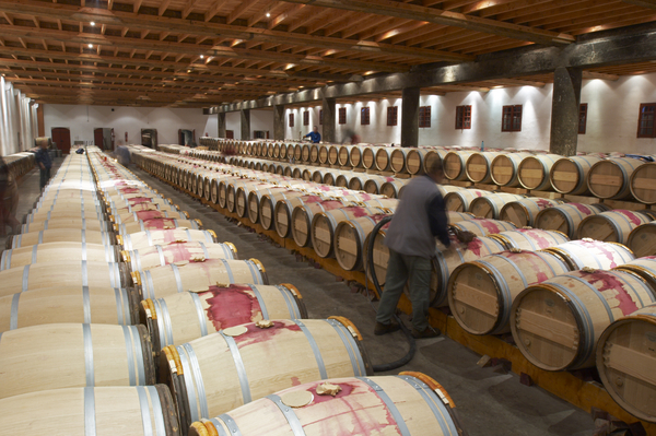 Topping up a wine barrel