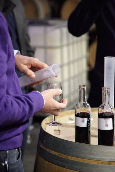 Carefully measuring wine in a measuring glass