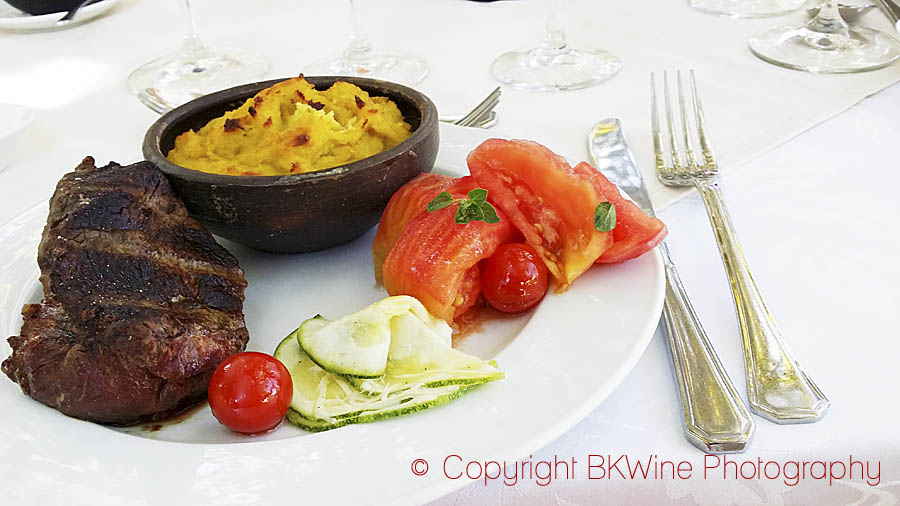 A grilled asado steak with fresh vegetables and corn paste (mashed maize, pastel de choclo)