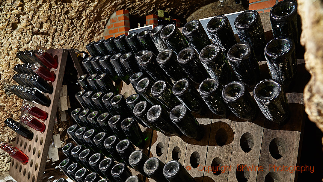 Bottles in pupitres in an underground cellar in Champagne