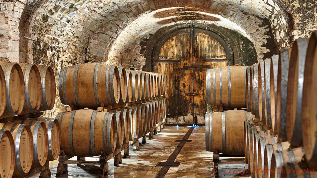 Oak barrels with ageing wine in a cellar in Tuscany