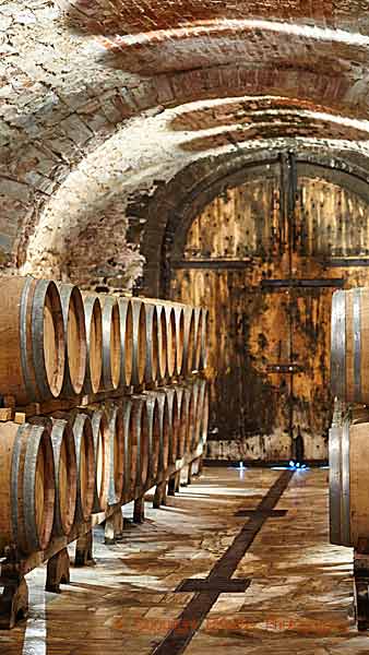 Oak barrels with ageing wine in a cellar in Tuscany