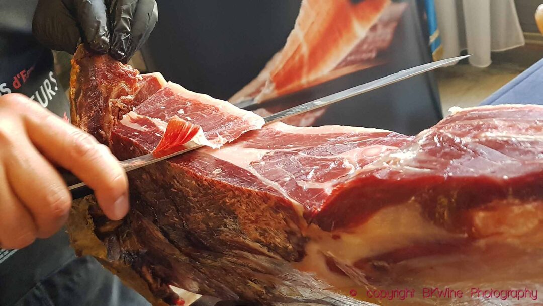 Cutting a slice of the delicious Spanish dry-cured ham, jamon iberico