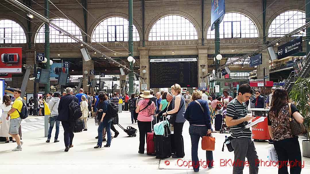 People at a train station in Paris, some with suitcases
